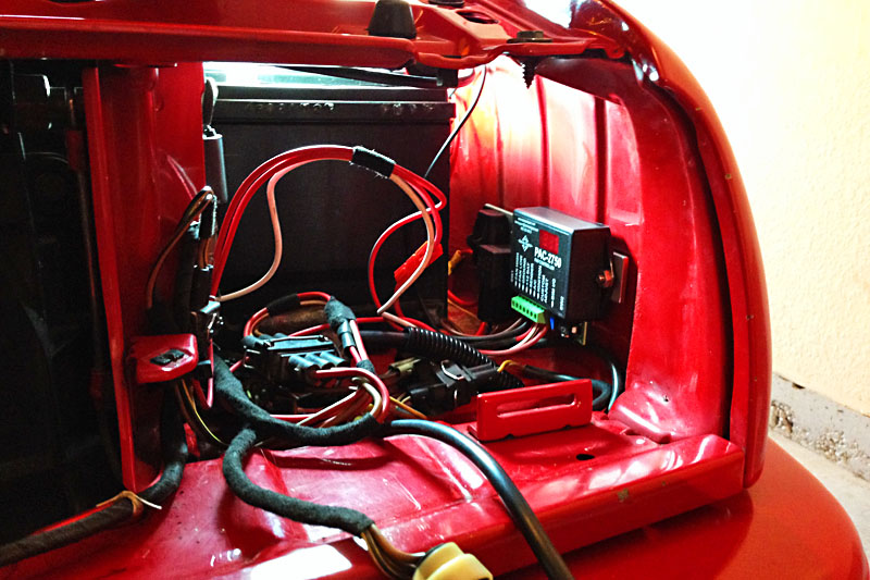 This picture shows a fuse holder, fan relay and programmable fan controller mounted on the cowl behind the left headlight. The components are mounted on a 1" aluminum rail which is attached to the cowl with two well nuts into existing holes in the sheet metal. <br><br>I'm using a Dakota Digital PAC‑2750 programmable fan controller to turn the oil cooler fans on and off. The controller has the profiles of several common temperature sensors built in, but I'm using a custom profile I mapped for my OEM oil temperature sensor. The controller makes it easy to map custom sensors as long as your vehicle has a gauge with a temperature readout in degrees F or C. I'm turning the fans on at 196&deg; F and off at 190&deg; F. Installation of the oil cooler fans controls the oil temperature in stop-and-go city traffic as well as under heavy loads when climbing the Rockies above 7,500' MSL. <span class='myGreyFont'>[End of series. <a href='../index.html'>Return</a> to the Automobile page.]</span>